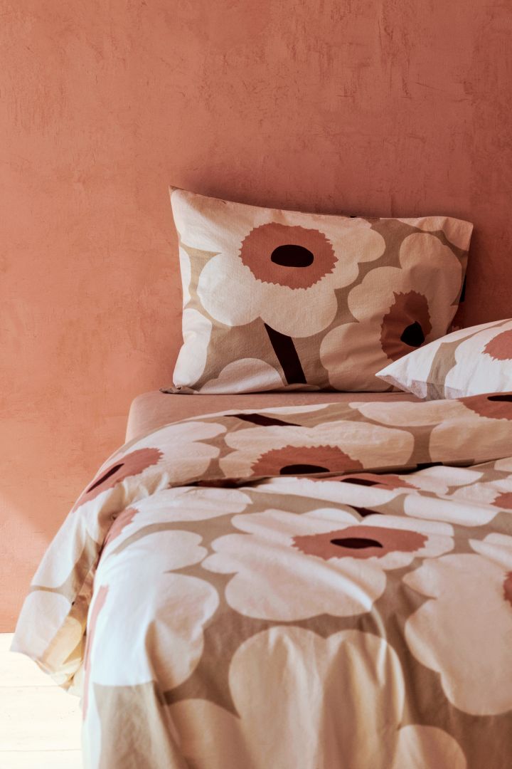 Peach coloured duvet cover with a flower motif from Marimekko, two of the biggest Scandinavian interior design trends for 2023.